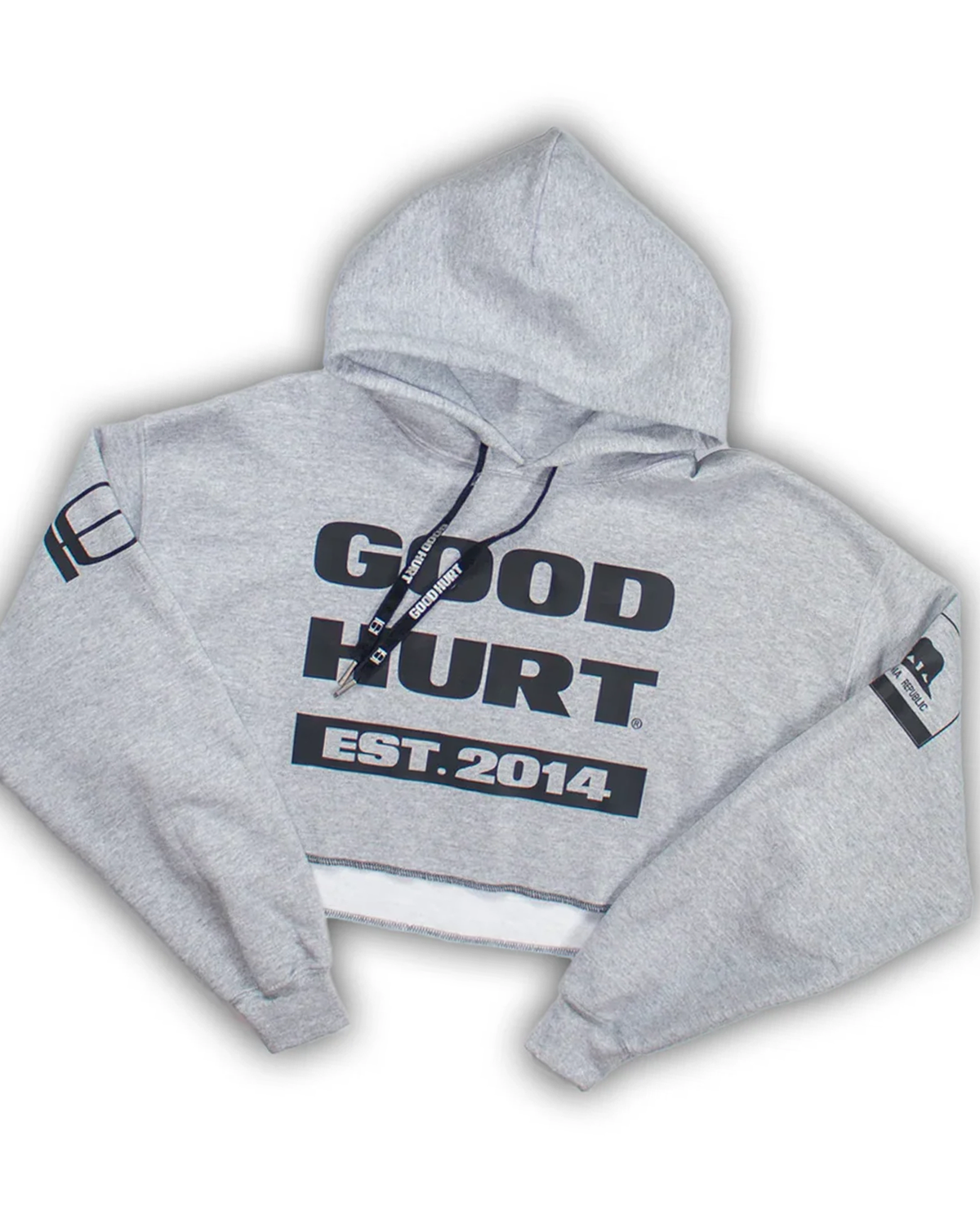 A light gray cropped hoodie with 'GOOD HURT EST. 2014' printed in black on the front, featuring black drawstrings and sleeve patches, shown on a white background.