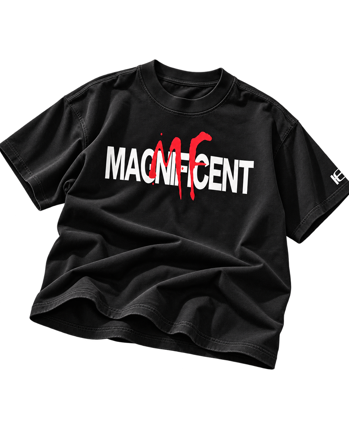 A black short-sleeve t-shirt with a graphic print on the front reading 'MAGNIFICENT' in white and red, styled with a drape on a plain white background.