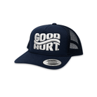 A navy blue trucker hat with white embroidered 'GOOD HURT.' text on the front, featuring a curved white stripe design and a silver Snapback visor sticker.